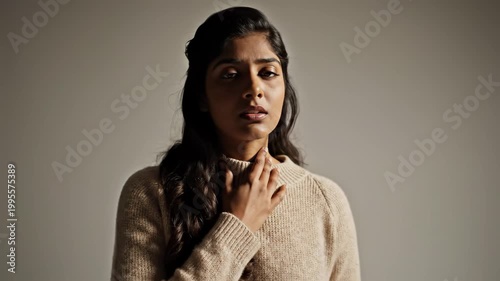 Young Woman Expressing Discomfort and Pain with Hand on Throat.