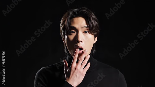 Surprised Asian Man with Dark Hair and Black Turtleneck.