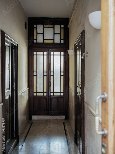 Vintage apartment hallway with wooden door and frosted glass panels