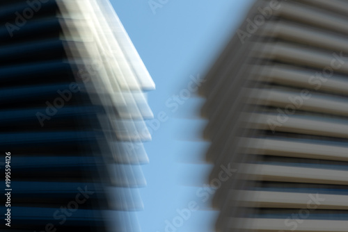 Abstract image of modern buildings with motion blur effect. Dynamic urban scene symbolising speed, fast-paced city life, business growth and modern architecture. Minimal composition with copy space