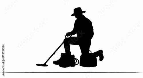 A man in silhouette kneels with a metal detector outdoors
