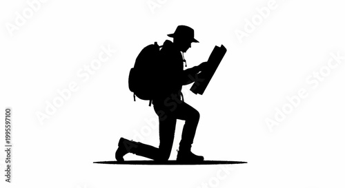A silhouette of a man kneeling down to study a map