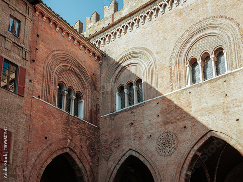 Historic brick architecture with arches and decorative windows in Piacenza
