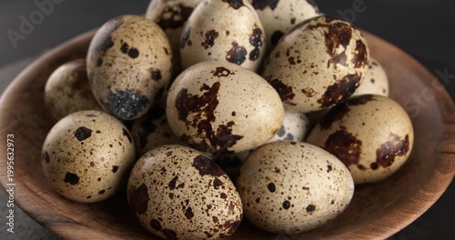 Quail eggs in a wooden bowl, close-up footage on a rotating table.