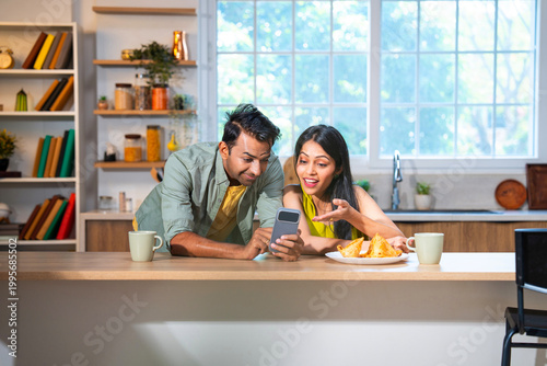 Photography Happy Indian couple surfing internet and checking photos on mobile phone in mode