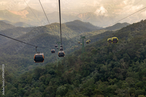 Tourists ride the cable car at Ba Na Hills, a mountain resort near Da Nang, Vietnam. Visitors enjoy scenic views and entertainment at this popular destination.