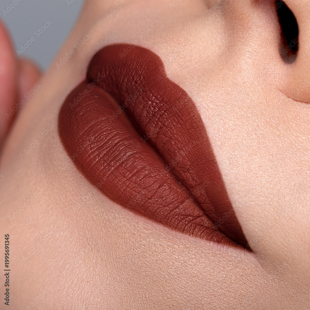 Fototapeta premium Warm brown matte lipstick on lips macro close up bold beauty look 