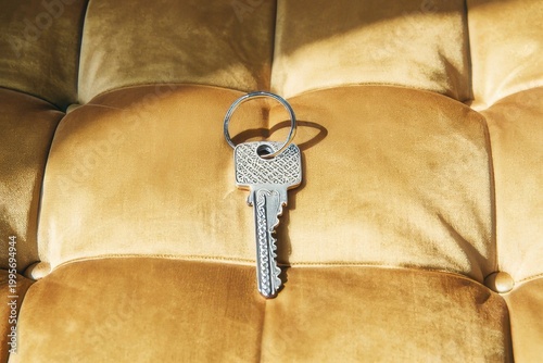 Silver Key on Golden Textured Surface Luxury Security and Property Concept
