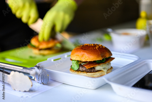 Close-up of a freshly prepared cheeseburger with beef patties, melted cheese and bun showcasing juicy gourmet street food ready to eat.