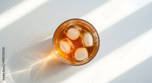 Refreshing amber beverage with glistening ice cubes, reflecting crisp light and inviting cool relaxation on a bright day