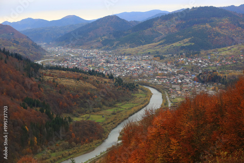 Scenic mountain valley town with a winding river and autumn foliage