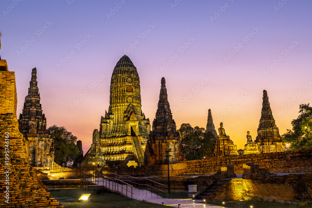 Fototapeta premium Beautiful ancient wat ayutthaya temple ruin glowing brightly under peaceful purple twilight sunset sky creating an inspiring tranquil historical landmark architecture for travel destination