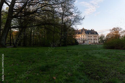 Park w Pszczynie wiosną o poranku, ciepłe światło słoneczne i świeża zieleń