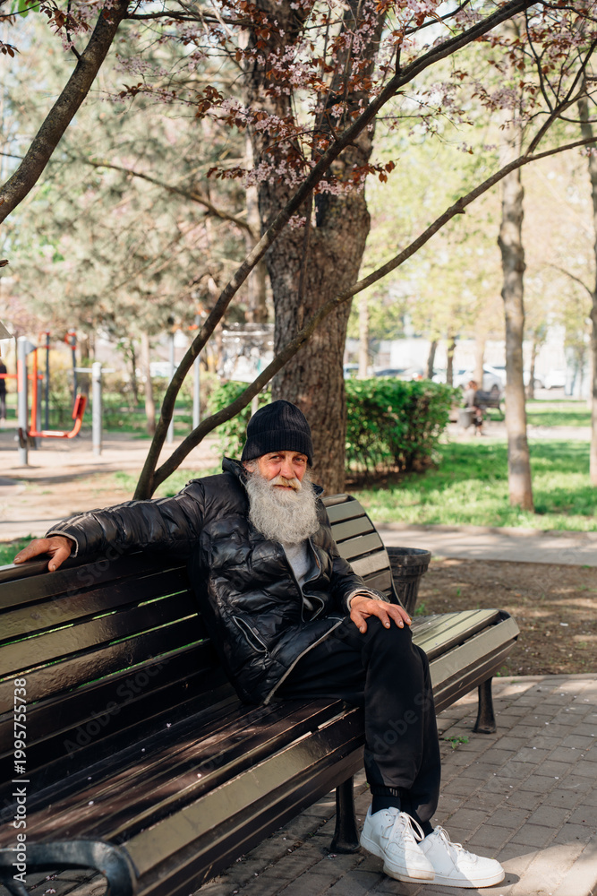Fototapeta premium homeless person. Man sitting on park bench in city during daytime
