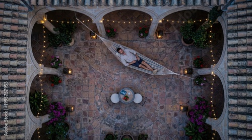 Man relaxing in hammock courtyard at dusk