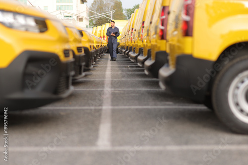 Fotografija Mechanic walking through a fleet of yellow vans