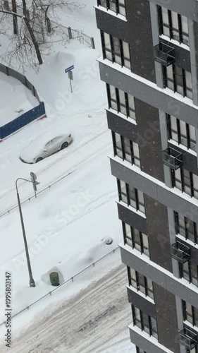 Snow covered residential street with parked cars after snowfall, winter urban environment