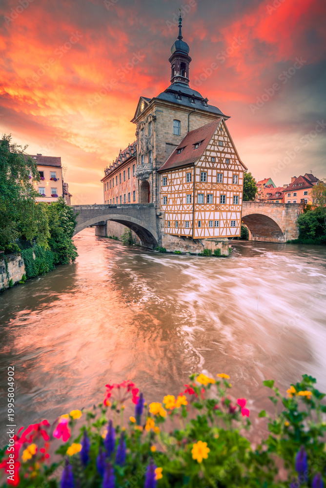 Fototapeta premium Bamberg, Bayern - Germany. Warm colors sunset over medieval downtown, vibrant sky and peaceful Regnitz river reflection