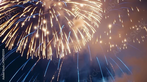 Glittering blue and gold fireworks bursting in festive celebration sky