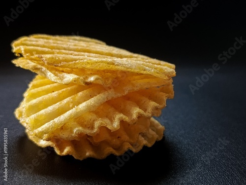 Fotografia Potato chips on black background