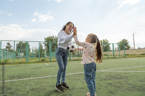 Women high fives her daughter on sport field