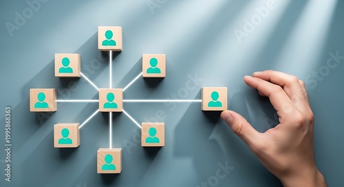 Hand connecting wooden blocks with human icons, symbolizing networking and teamwork in a professional business environment, concept of social connections.
