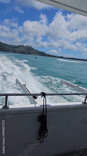 Boat moving on turquoise ocean with wake trail, tropical travel and vacation concept