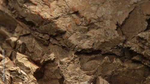 Close-up layered rock surface with dry cracked earthy texture