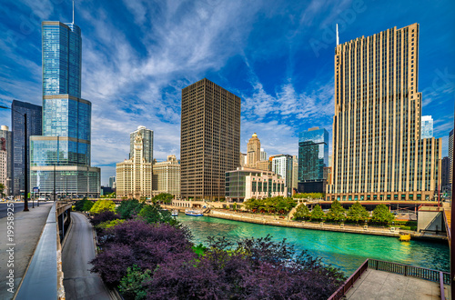 Stunning panoramic view of the Chicago River flowing through downtown skyscrapers, a vibrant blue sky with wispy clouds