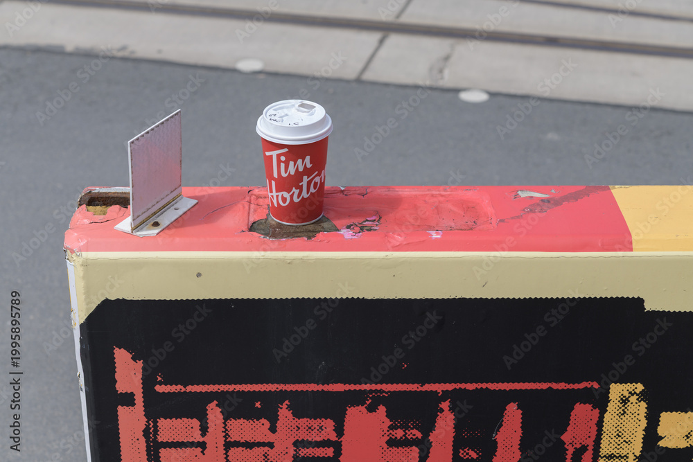 Fototapeta premium discarded Tim Hortons beverage cup on a concrete divider in Toronto