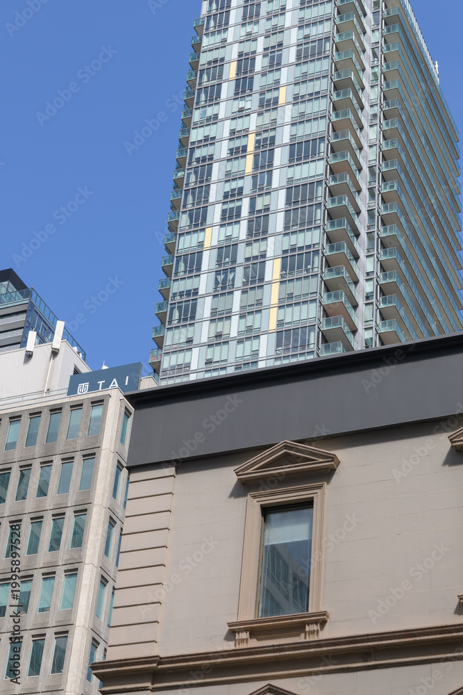 Fototapeta premium historic building window at 25 Toronto St contrast with Spire, a condominium complex, at 100 Church St, Toronto