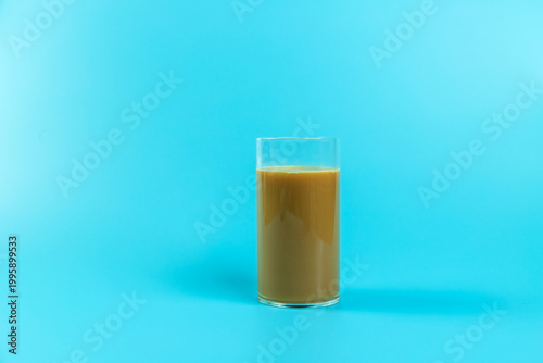 A coffee drink contained in a glass on a plain background