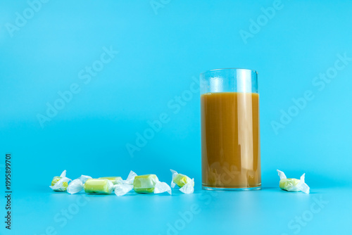 Candies in a solid-colored background and coffee beverages in a glass cup