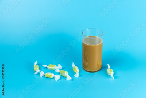 Candies in a solid-colored background and coffee beverages in a glass cup