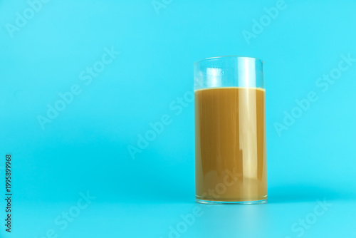 A coffee drink contained in a glass on a plain background