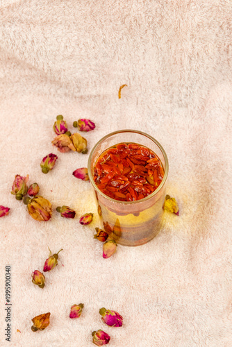 The water made from dried red dates and goji berries in the transparent glass cup