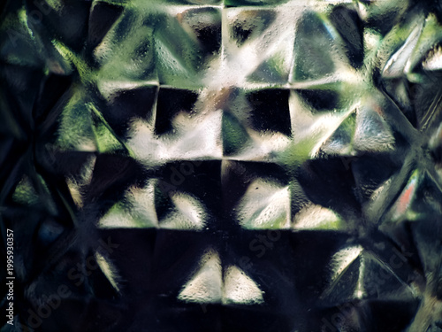 Abstract geometric pattern featuring a textured surface with a grid of triangular facets. 