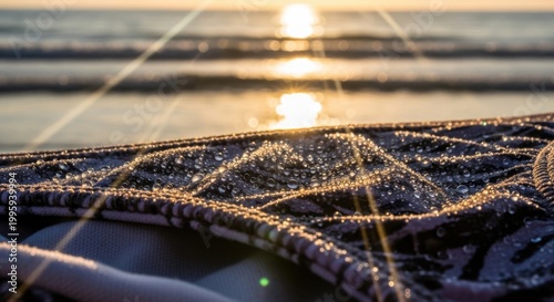 Golden Hour Glow on Wet Fishing Net with Ocean Sunset Background.