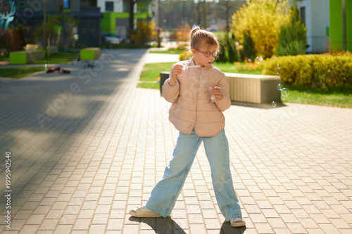 Young girl blowing bubbles in an outdoor residential area