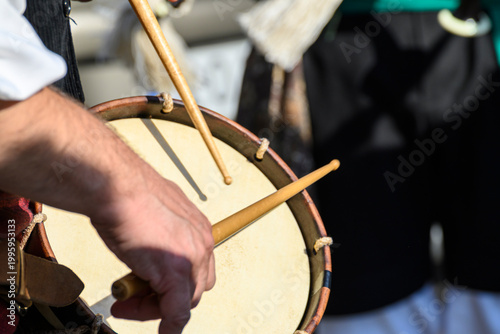 Photos Action shot of a person drumming with sticks on a leather drum skin
