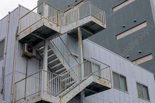Rusty metal staircase on building facade in urban environment