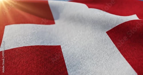 Switzerland flag waving in the wind with bright golden sunlight