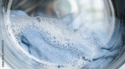 Close up of fabric with foam inside washing machine during laundry cycle