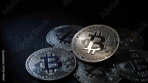 Close-up of Bitcoin cryptocurrency coin surrounded by other digital coins. Concept of blockchain technology, crypto trading, digital assets, and financial investment