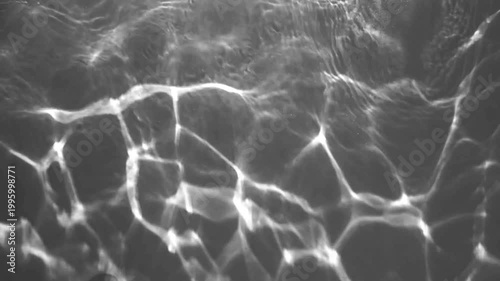 Monochrome shimmering water light pattern in aquarium, elegant abstract moving background footage