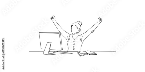A woman sitting at a desk with her arms raised in celebration next to a computer and book