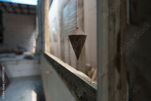 фотографія The focus is on using plumb bobs in plastering and working on construction projects