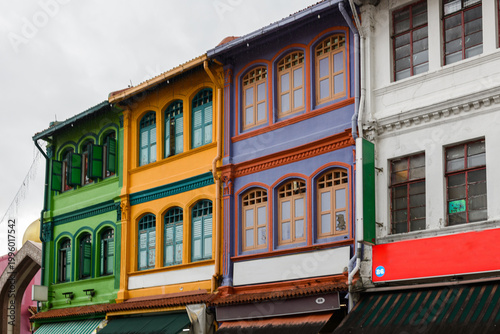 Fotografía Exterior architectural detail of the facade of ornate, colorful, traditional, old, colonial-era buildings in the Arab neighborhood of  Kampong Glam, a historic district near Bugis, Singagpore