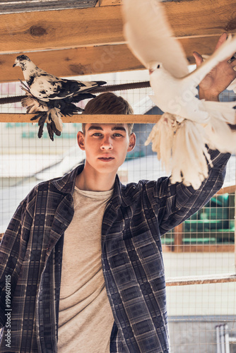 Portrait of a young man in a dovecote with his pet pigeons
