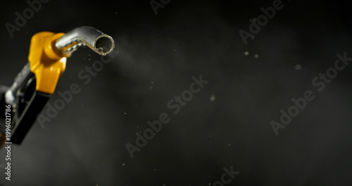 Photography Gasoline droplets spraying from fuel nozzle on dark background, minimal остатky fuel flow